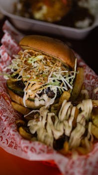 Mouth-watering burger with fresh toppings and cheesy fries, perfect for fast food lovers.