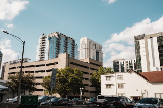 Vibrant downtown cityscape featuring modern buildings under a blue sky, capturing urban life.