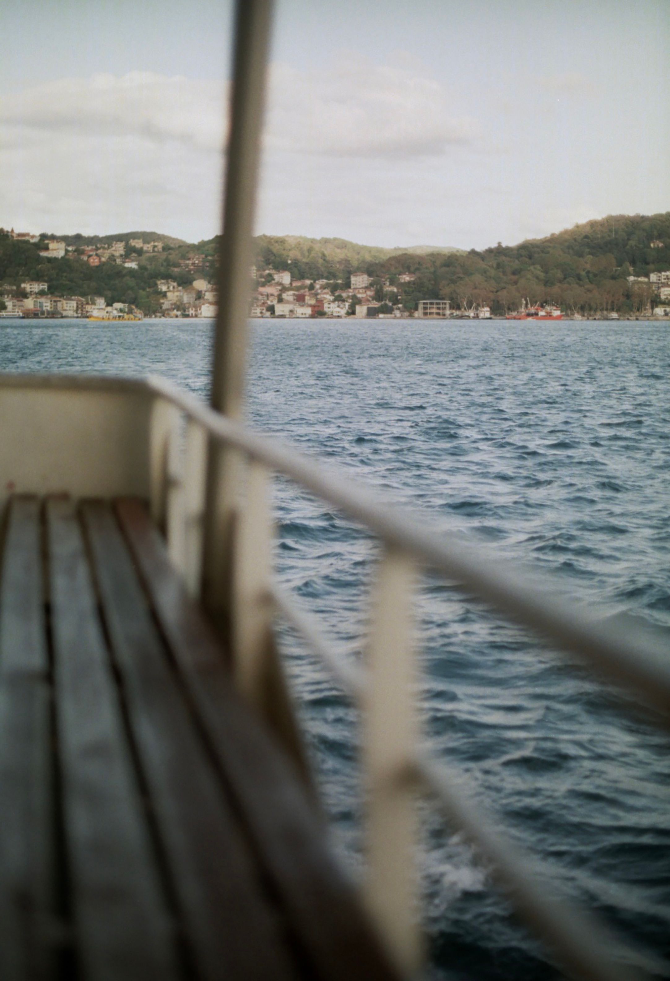 Peaceful view from a boat overlooking a coastal town and blue ocean waters.
