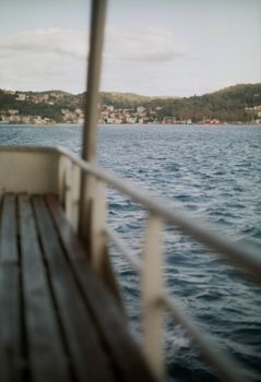 Peaceful view from a boat overlooking a coastal town and blue ocean waters.