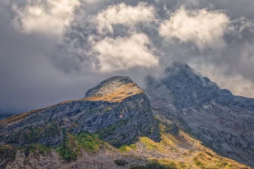 Free Stunning mountain landscape with rocky peaks under a vibrant cloudy sky, perfect for nature lovers. Stock Photo