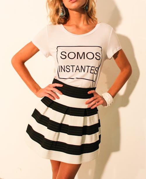 Woman Wearing White Shirt and Black and White Striped Skirt Posing