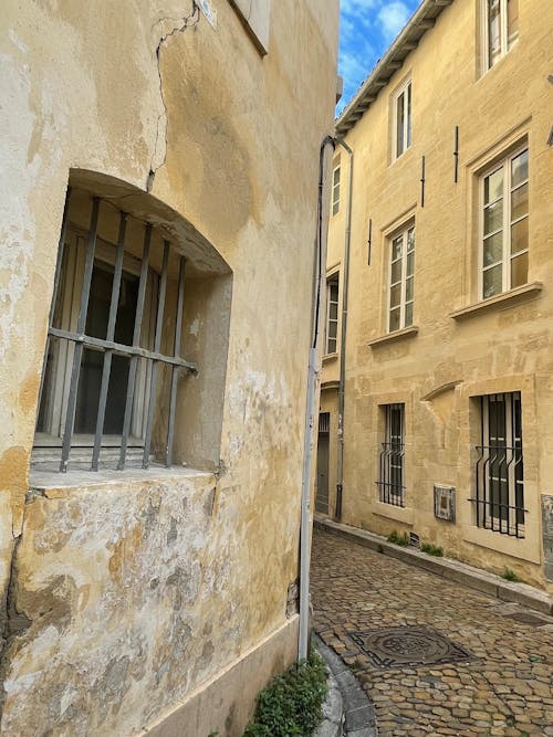 Immagine gratuita di ciottolo, edificio in pietra gialla, strade di ciottoli