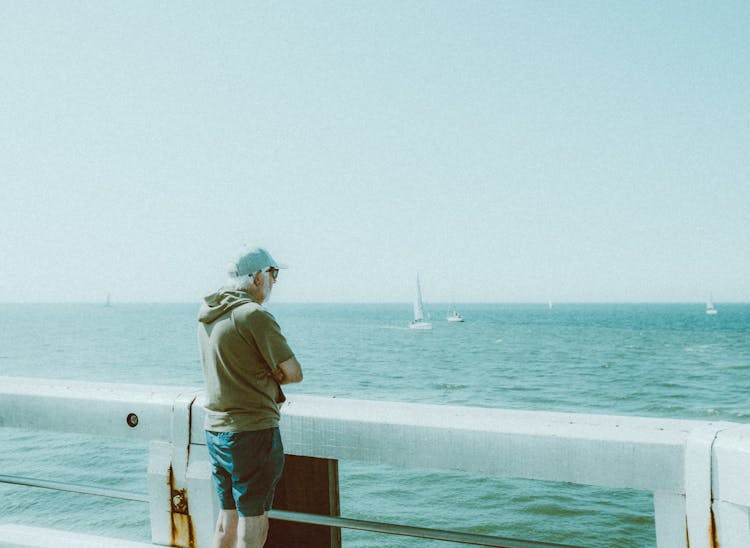 Man Watching Sailboats On Sea