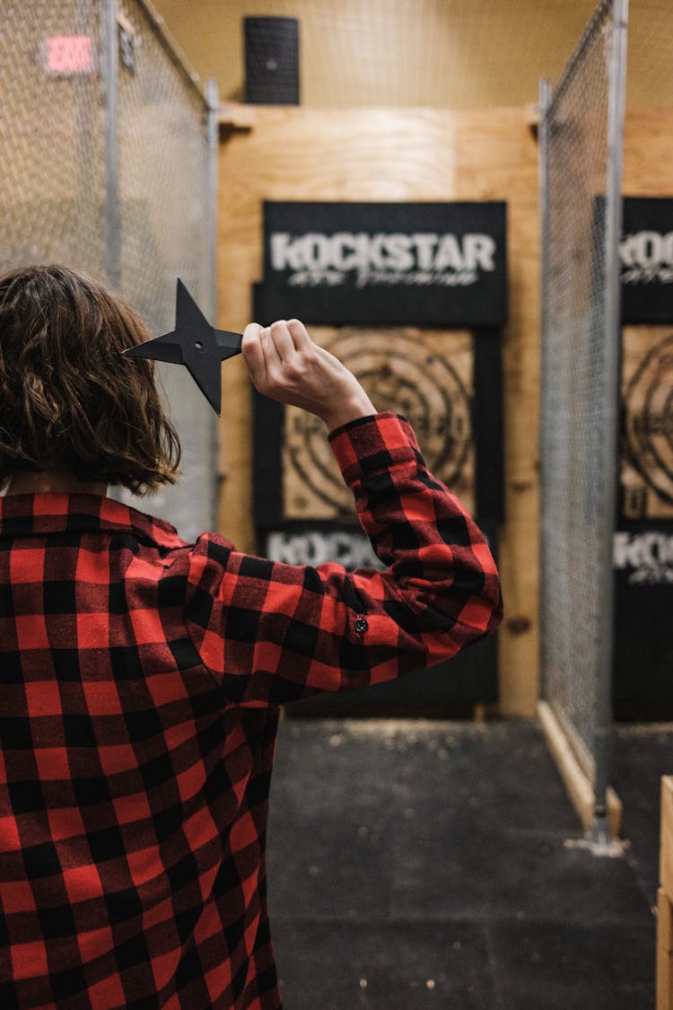 Back View Of Woman In Red Shirt Throwing Star