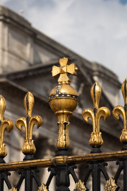 Free Close-up of a golden fence with fleur-de-lis detail outside Buckingham Palace in London. Stock Photo