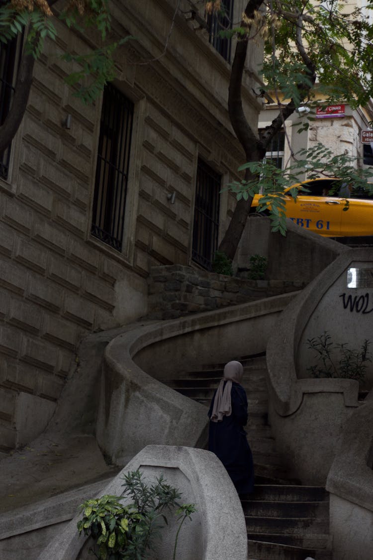 Woman Walking Up A Stone Staircase