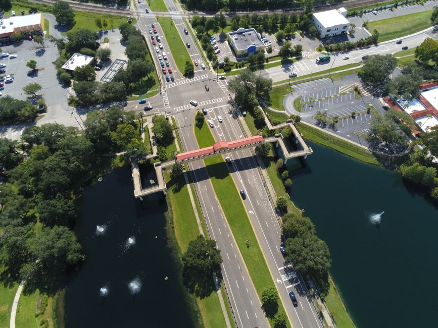 Outstanding Day Flight 48 Miles Helicopter Tour over Theme Parks & Downtown Review 2026 - A stunning aerial view of a busy intersection and footbridge surrounded by water in Lake Mary, Florida.