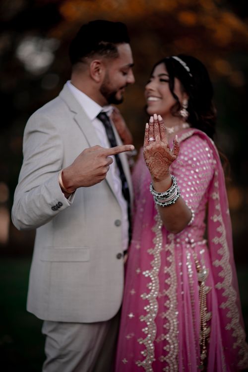 Free Smiling Indian couple in traditional attire showcasing wedding rings in a joyful moment. Stock Photo