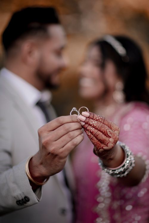 Free A bride and groom displaying their wedding rings in a romantic, intimate moment. Stock Photo