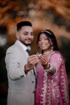 Indian bride and groom celebrating their wedding, holding rings, showcasing Indian culture.
