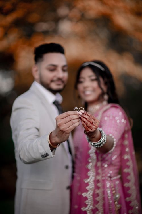 Free Indian bride and groom celebrating their wedding, holding rings, showcasing Indian culture. Stock Photo