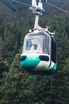 A gondola ride over the scenic forest landscape of Banff, Canada. Perfect for travel and nature enthusiasts.