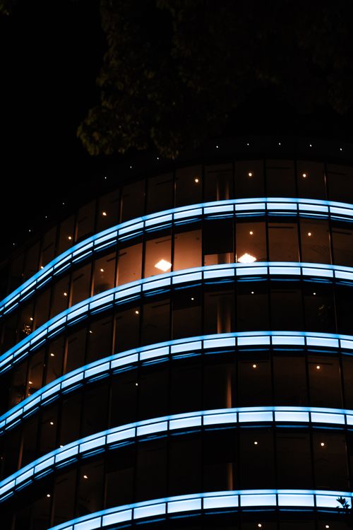 Free Low-angle view of a modern glass building illuminated at night in Buenos Aires, Argentina. Stock Photo