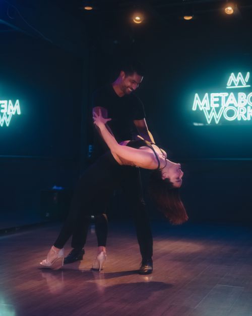 Free A couple dances energetically under neon lights, capturing the essence of nightlife fun. Stock Photo