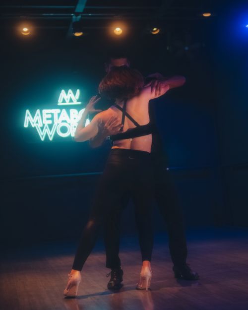 Free Couple performing dance in a studio setting, illuminated by vibrant neon lights creating a dynamic atmosphere. Stock Photo