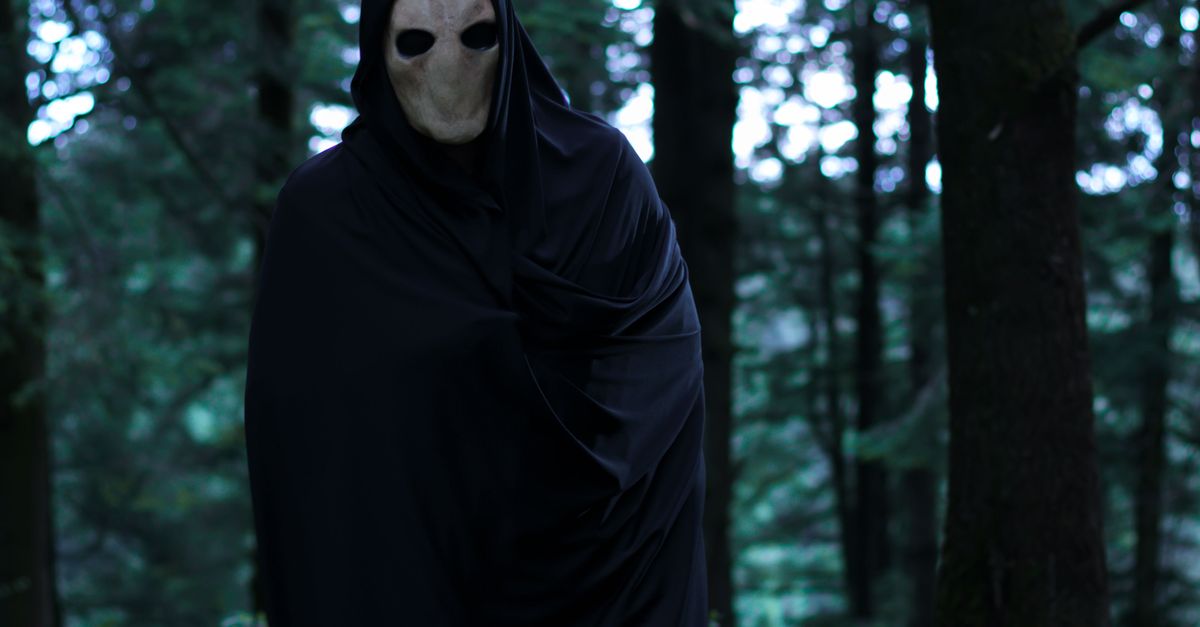 Man In A Mask A Man in a Mask and Black Robe in the Forest · Free Stock Photo