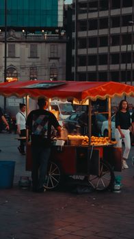A vibrant street food scene with a vendor selling corn at dusk in Istanbul, Turkey.