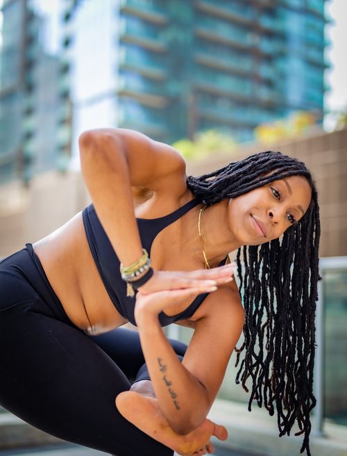 Free A young woman practicing yoga outdoors embodies focus and fitness in a city setting. Stock Photo
