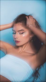 Artistic portrait of a young woman in a tube top with dramatic lighting and soft focus.