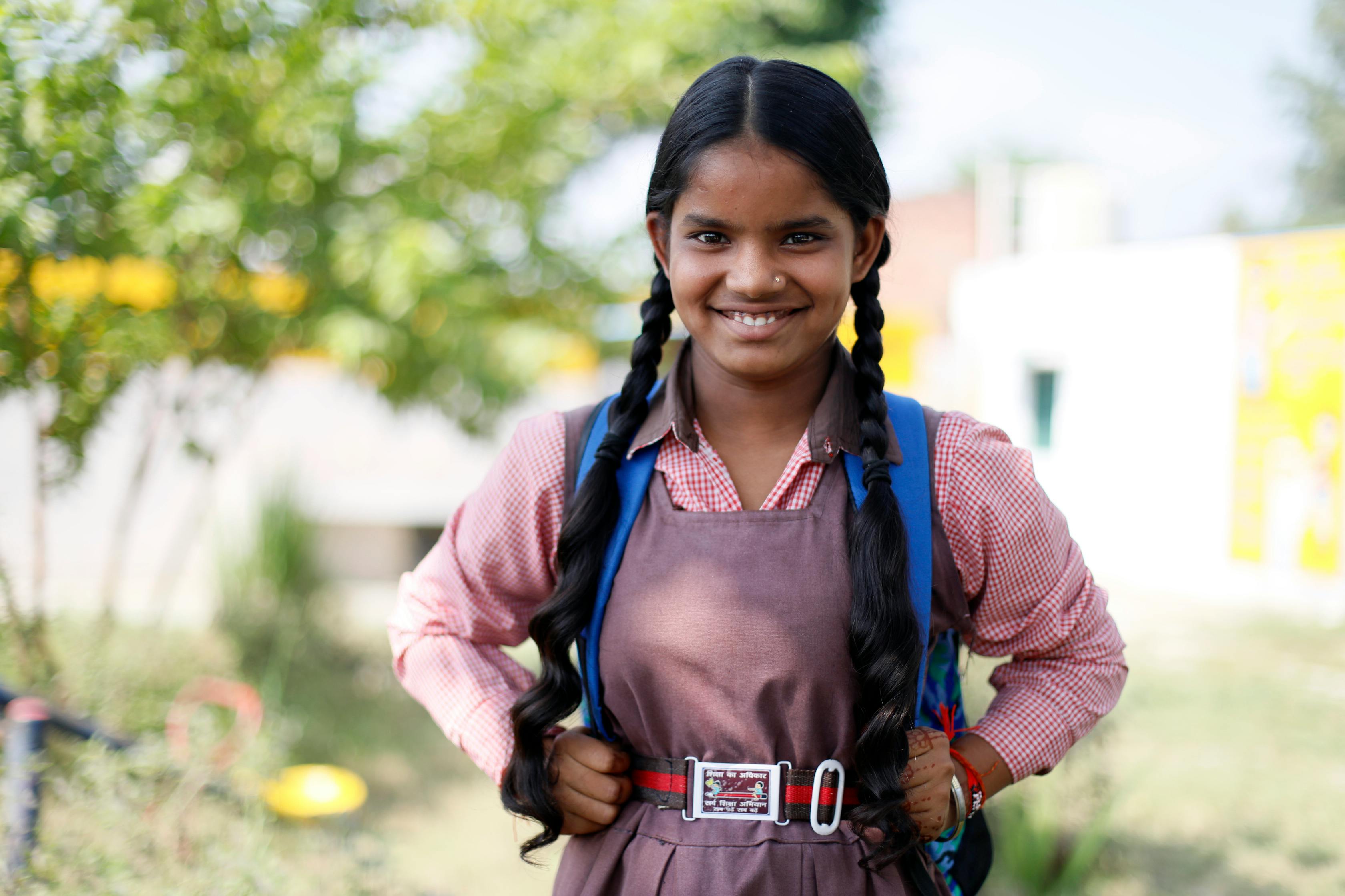 Cheerful Indian schoolgirl in uniform smiling outdoors in Lucknow, India.