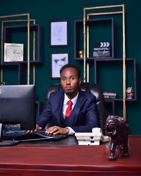 Focused businessman in suit working at office desk with computer.