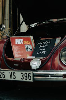 A vintage car displaying antiques and vinyl records at a boot sale, capturing nostalgia.