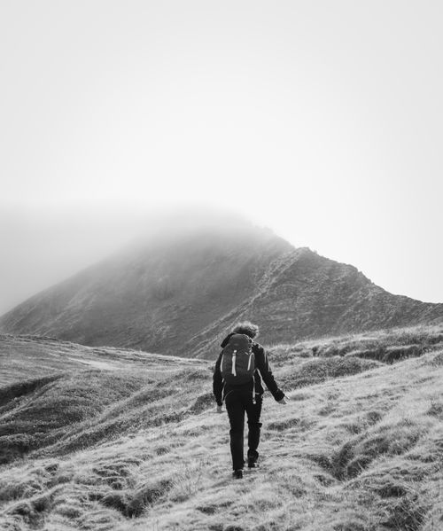 Free Black and white photo of a hiker on a misty mountain trail in Albania. Stock Photo