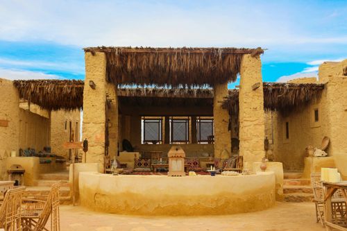 Free Traditional adobe house featuring a rustic terrace and natural materials under a bright blue sky. Stock Photo