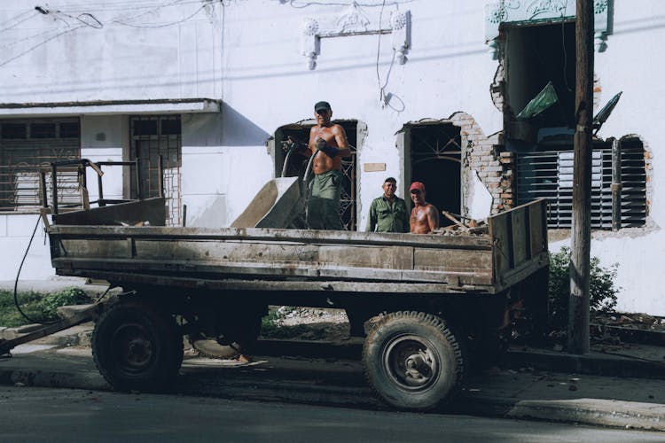 Men Loading Construction Debris In A Hauler