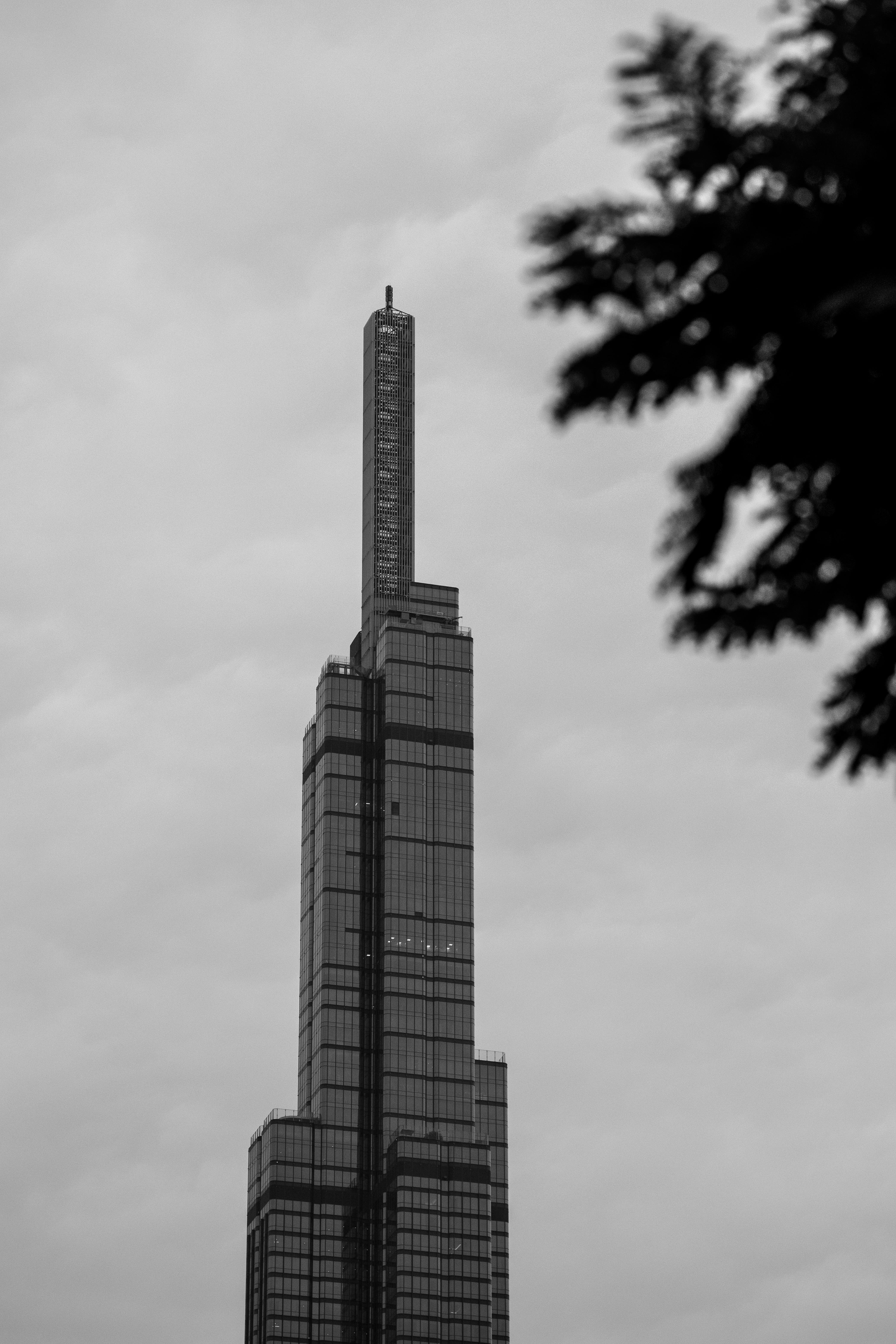 Monochrome photo of a towering skyscraper in a cloudy skyline, Vietnam.