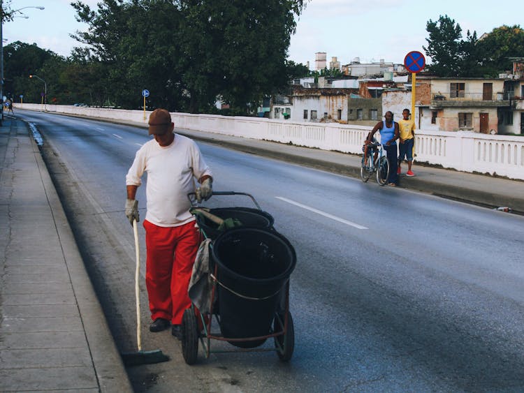 A Man Cleaning The Sidewalk