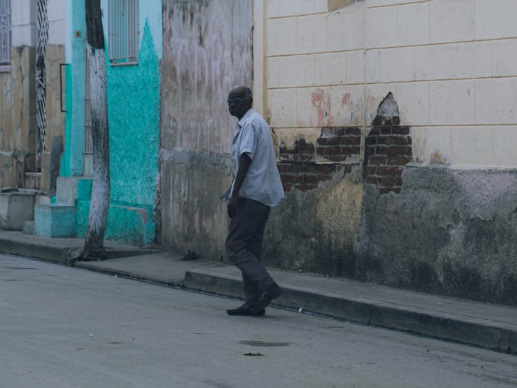 A Man Walking On A Sidewalk