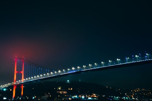 Free Striking night view of Bosphorus Bridge with vivid lights illuminating Istanbul skyline. Stock Photo