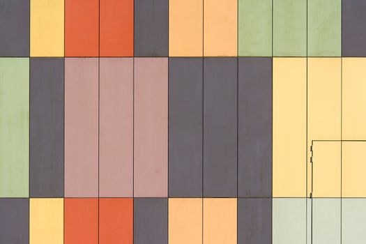 Abstract geometric facade with colorful panels creating a patterned design.