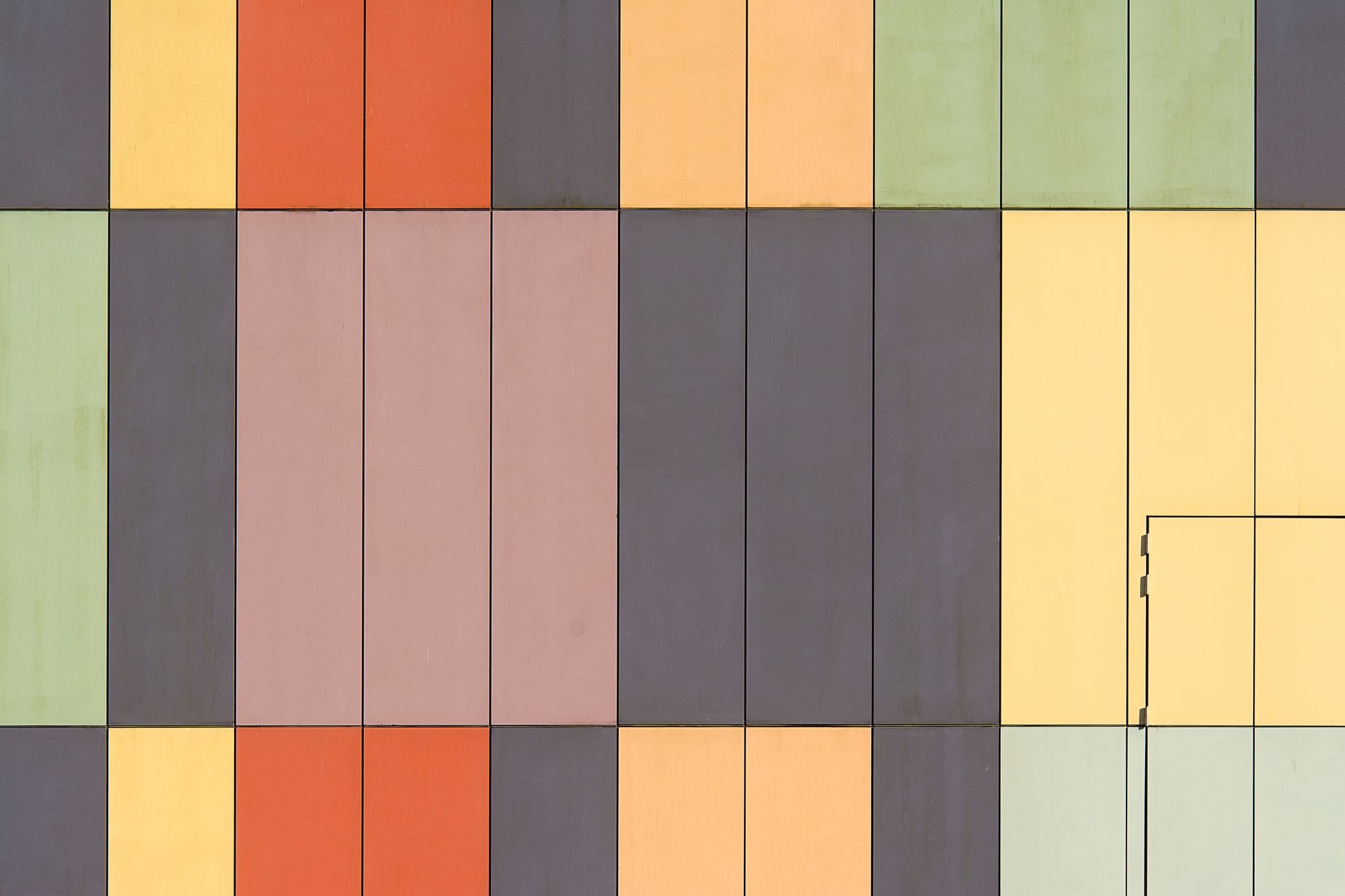 Abstract geometric facade with colorful panels creating a patterned design.