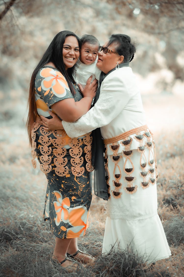 Mother And Grandmother Hugging A Toddler