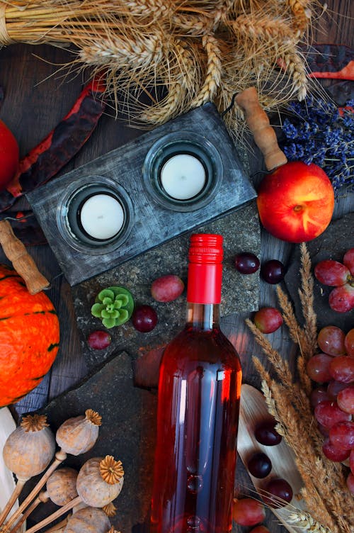 Grauer Kerzenhalter In Der Nähe Von Glasflasche Und Runder Roter Frucht Auf Grauer Holzoberfläche