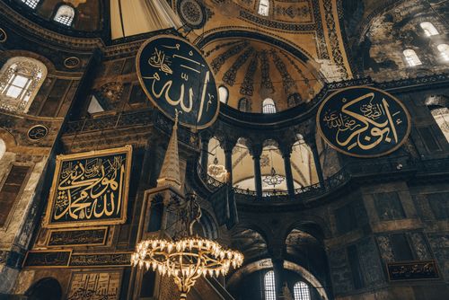 Free Ornate interior view of historic mosque with Arabic calligraphy and chandelier. Stock Photo