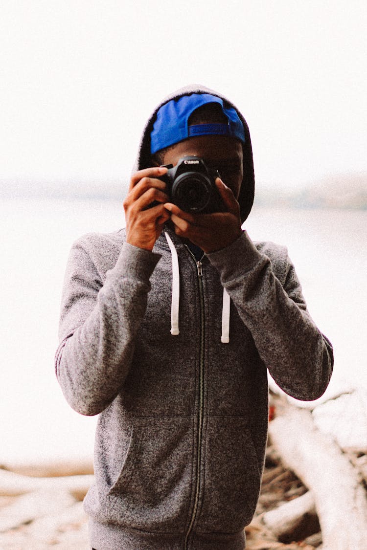 Man In Gray Hoodie Taking Pictures