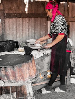 Woman in Azerbaijan preparing traditional bread in a rustic setting. Cultural heritage vividly captured.