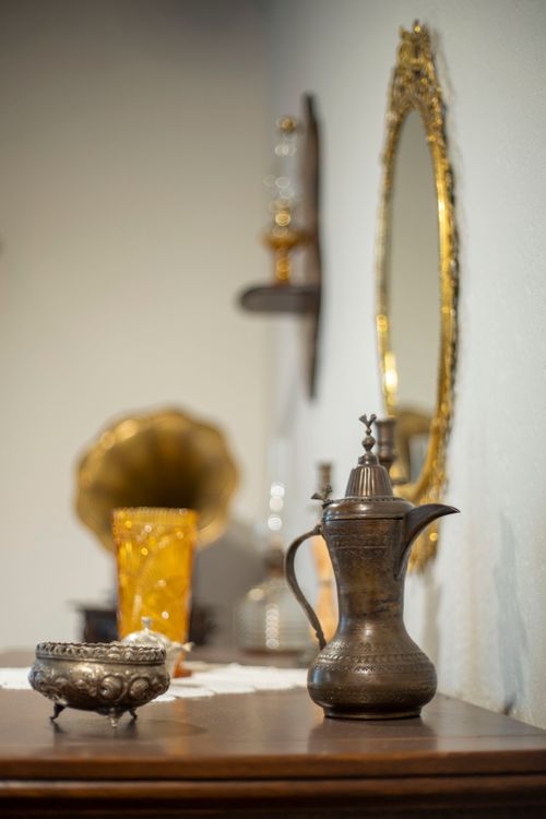 Free A classic brass teapot on a wooden table with vintage decor and a mirror. Stock Photo