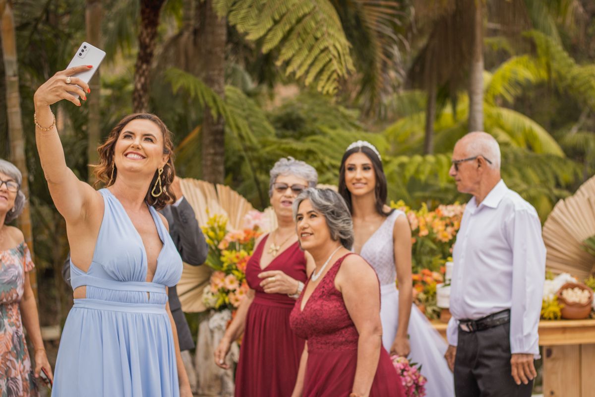 Invités de plusieurs générations prenant une photo ensemble pendant un mariage