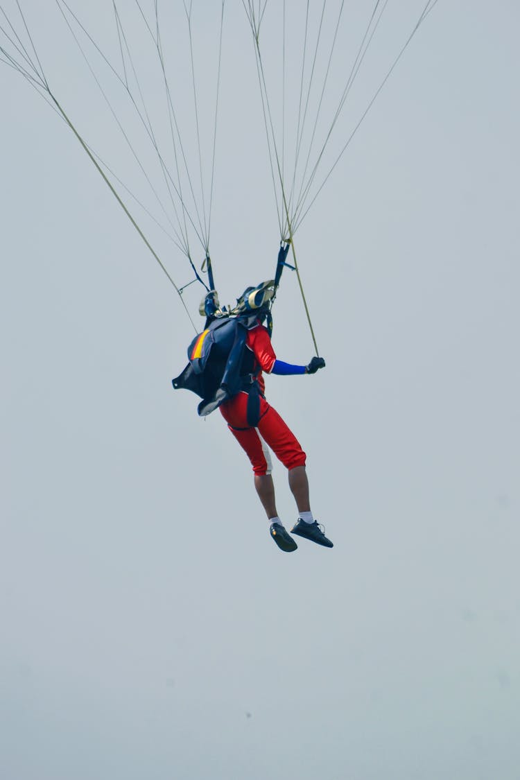 Person Flying On Parachute In Sky