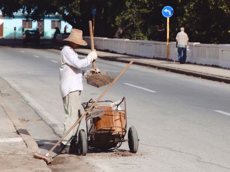 Man in White Dress Shirt and White Pants Holding Brown Wooden Cart