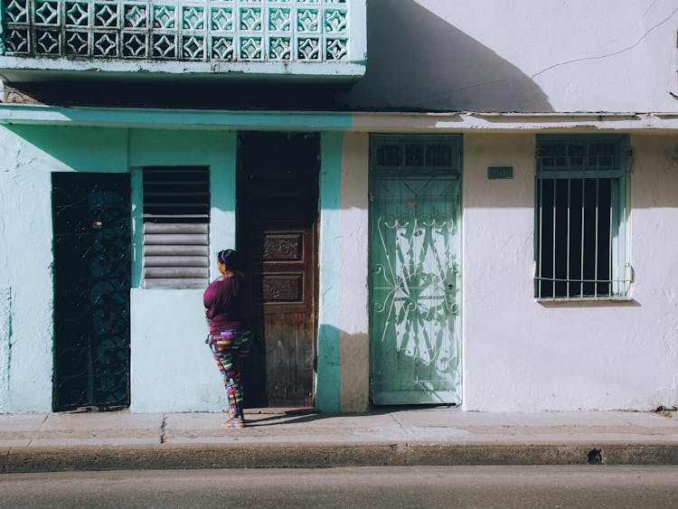 Woman Standing At The Door To An Old Urban Building 