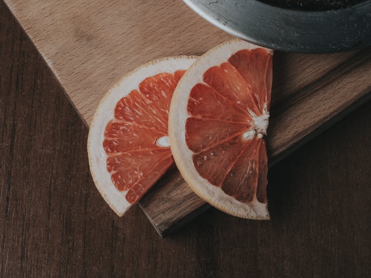 Sliced Orange Fruit On Brown Wooden Chopping Board