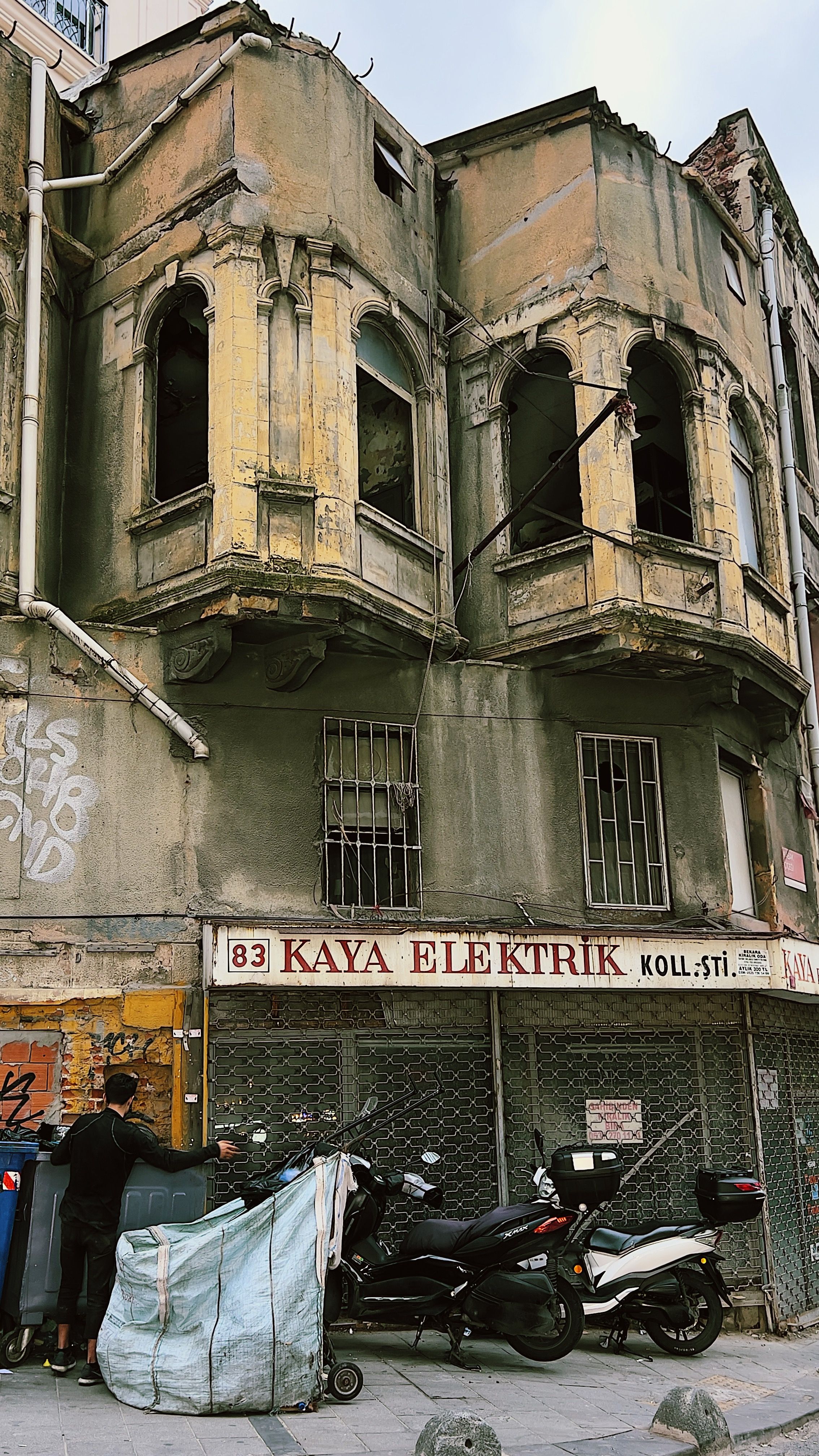 An urban scene featuring a weathered building with vintage architecture and street detail.