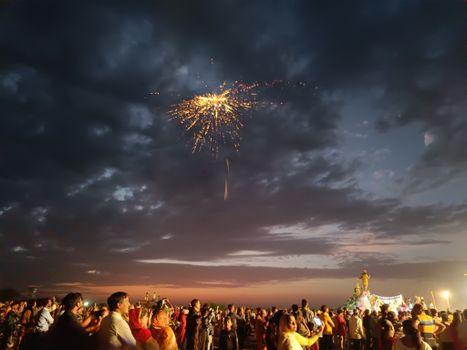Crowd gathered under colorful fireworks during a festive Diwali evening in Gangapur, India.