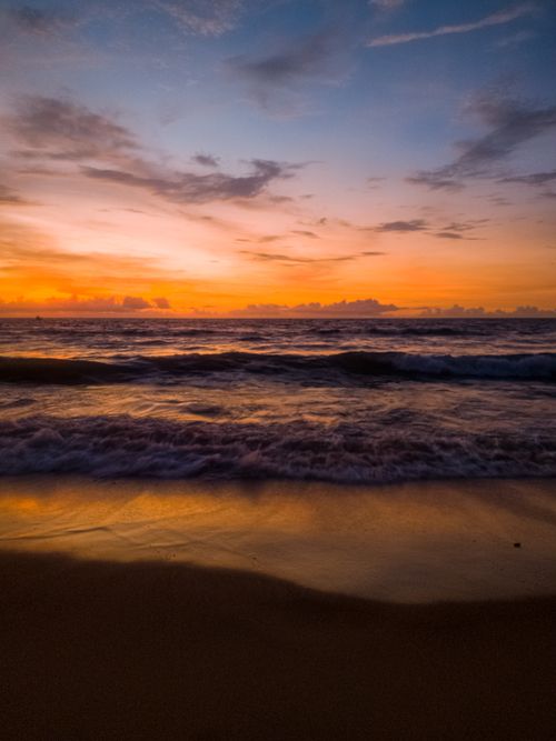 Free Captivating sunset over the ocean with vibrant orange and blue hues. Stock Photo